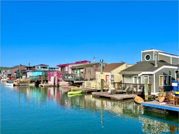 Houses floating in the water against a blue sky.