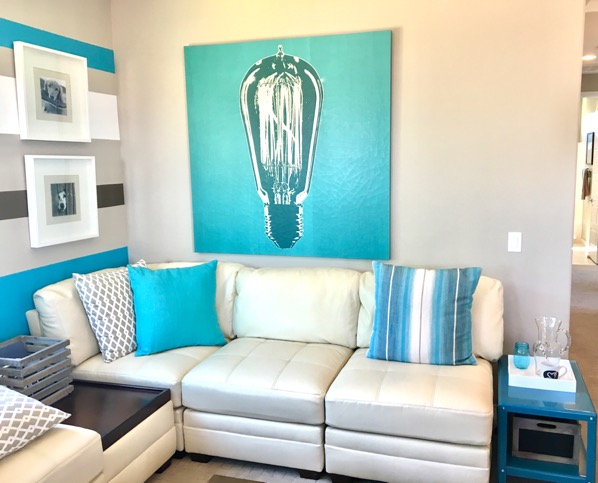 Living room with throw pillows on couch and artwork on walls.