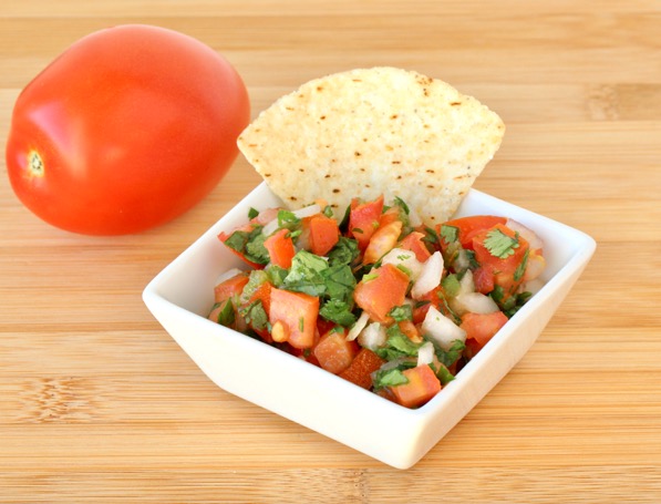 Chip dipping into a bowl of Pico de Gallo.
