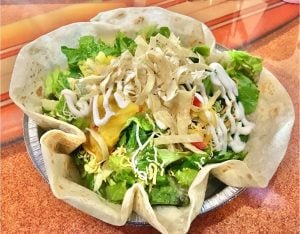 Grilled tilapia fish taco bowl in a soft tortilla.