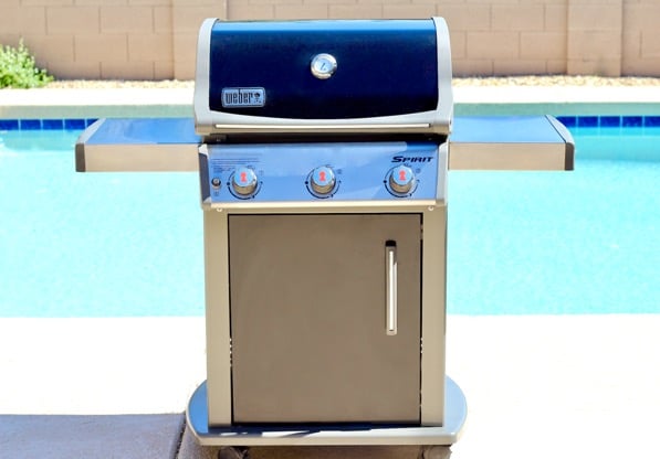 Weber grill in front of a pool.