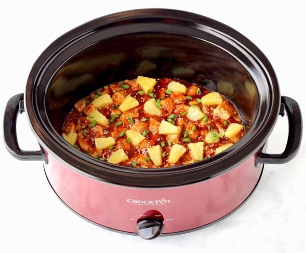Sweet and sour pork in a red Crock Pot.