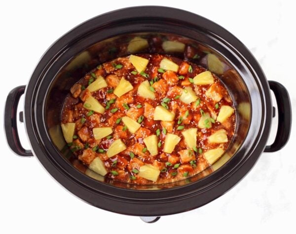 Sweet and sour pork with pineapple chunks in a Crockpot.