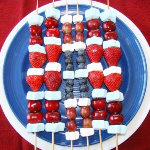 Red white and blue fruit kabobs with strawberries, cherries, blueberries, and marshmallows.