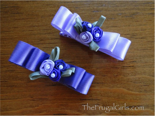 Two double bow hair clips with flowers in center.
