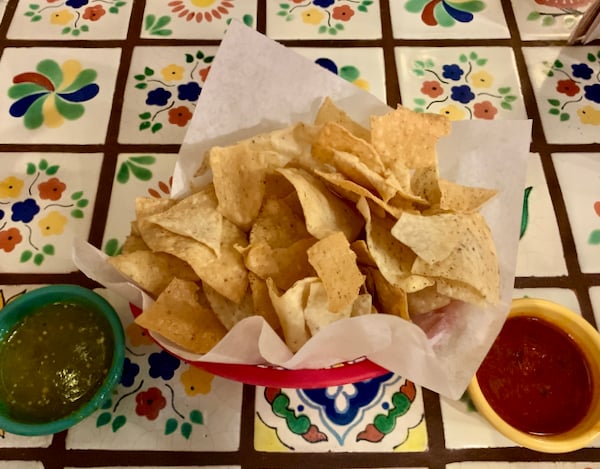 Chips and salsa on a colorful tile table.
