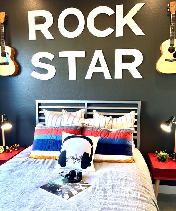 Bed with the words \"Rock Star\" on the wall.