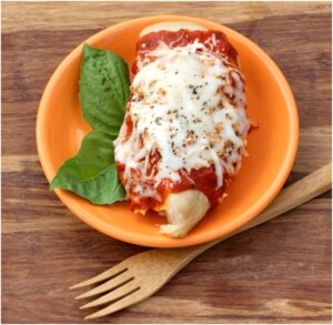 Cooked chicken on plate with marinara sauce and melted cheese on top.