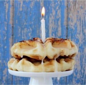 Cinnamon roll waffles on plate with candle.