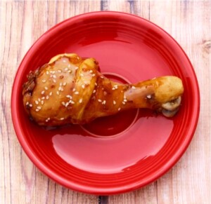 Cooked drumstick on plate with teriyaki sauce.