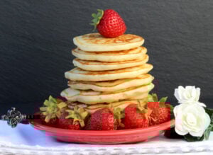 Stack of pancakes with strawberry on top.