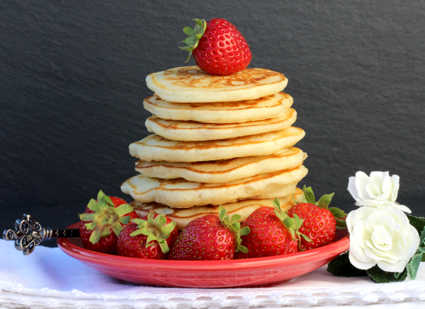 Stack of pancakes with strawberry on top.