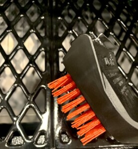 Grill brush with red bristles.