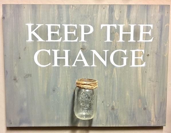 Mason jar on a board that says \"Keep the Change.\"