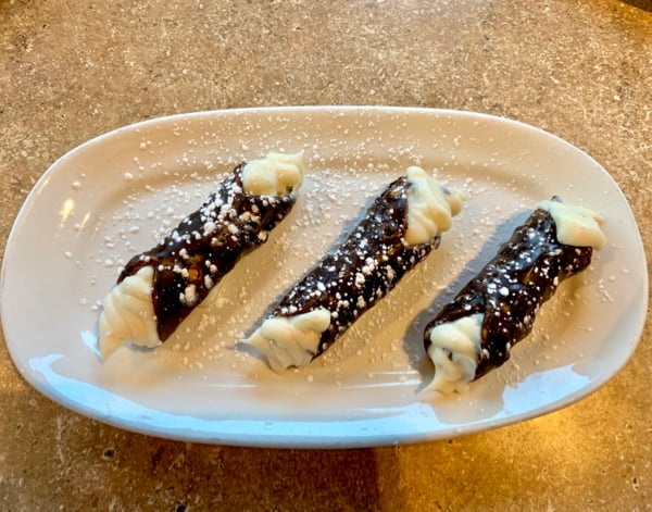 A rectangular plate with 3 cannolis.