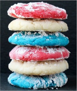 Stack of red white and blue cookies coated with powdered sugar.