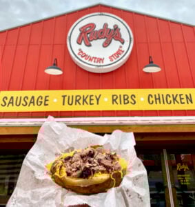 Loaded baked potato in front of Rudy\'s BBQ restaurant.