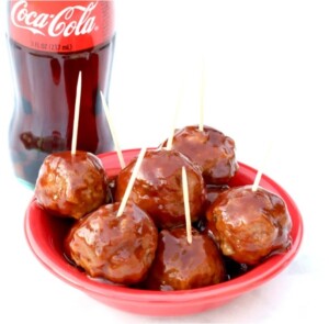 Cooked meatballs in dish with barbecue sauce and toothpicks.
