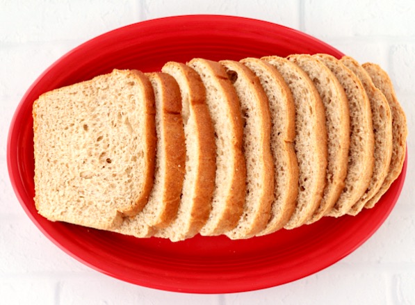A red platter with slices of bread laid neatly on it.