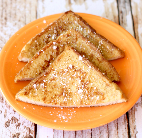 Triangle shaped French Toast slices neatly arranged on an orange plate.