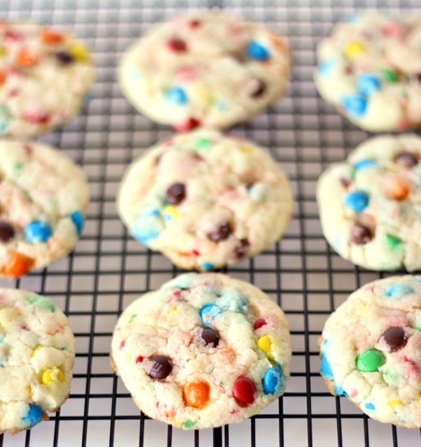 Funfetti cookies arranged on a black cooling rack.