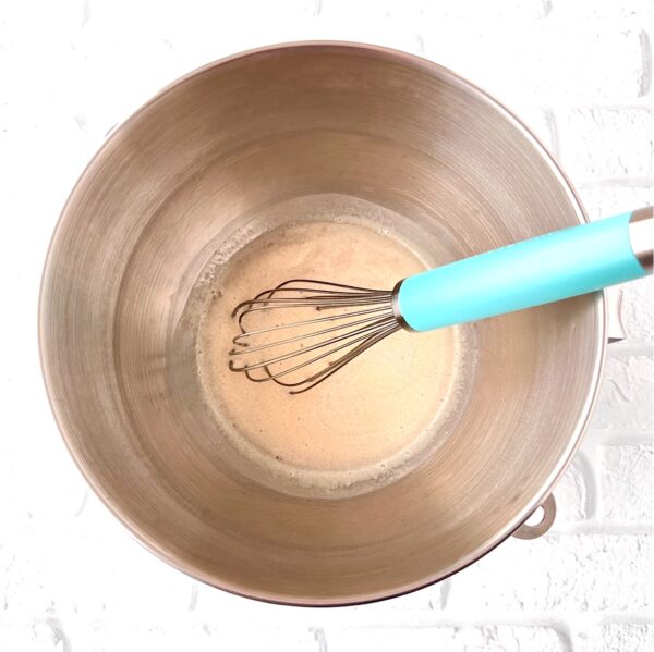Active dry yeast with sugar, water, and whisk in mixing bowl.