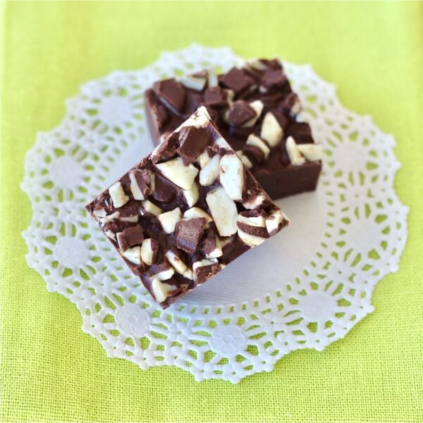Two pieces of chocolate Andes Mint Fudge on doily.