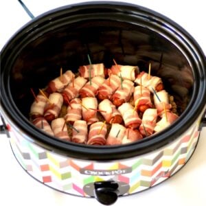Bacon wrapped smokies with brown sugar in crockpot, with toothpicks inserted.