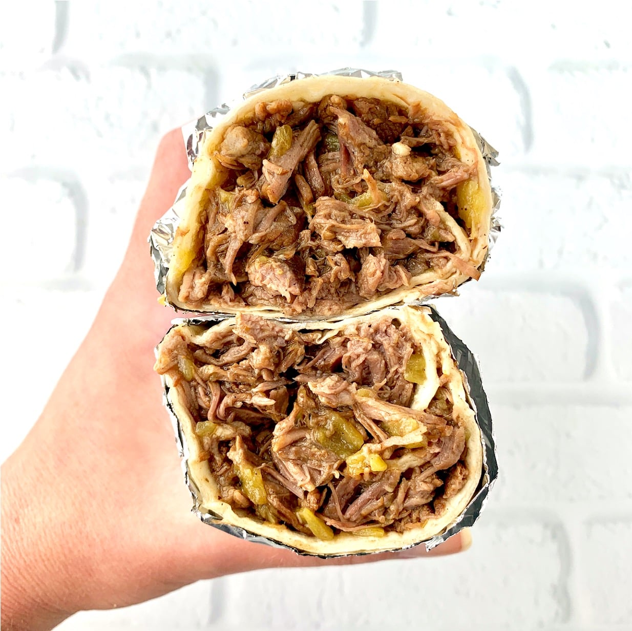 Beef burrito cut in half, with two halves stacked on top of each other.