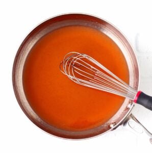 Whisk with sweet and sour sauce in pan.