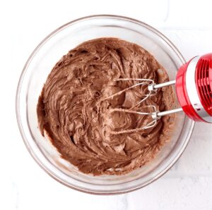 Chocolate cookie dough in bowl with mixer.