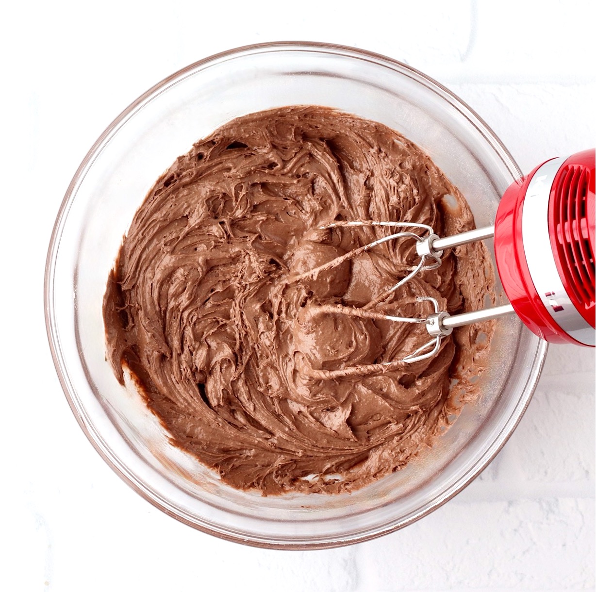Chocolate cookie dough in bowl with mixer.