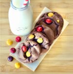 Five chocolate peanut butter cookies on napkin with peanut butter M&M's to the side.