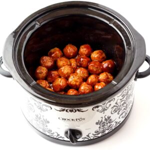 Cooked meatballs in crock pot glazed with honey garlic sauce.
