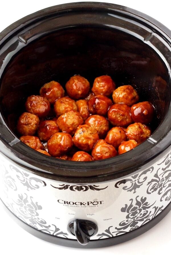 Cooked meatballs in crock pot glazed with honey garlic sauce.
