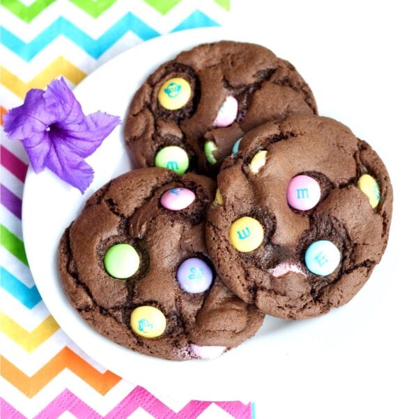 Three chocolate Easter M&M cookies on plate.