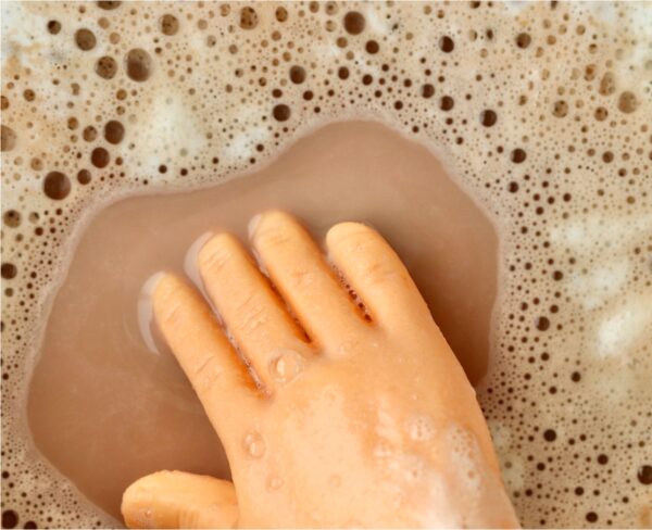 Tiny hand in crockpot filled with cocoa.