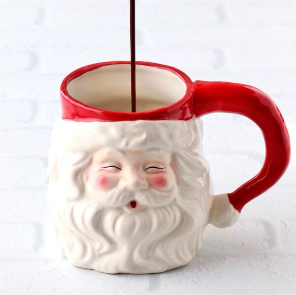 Chocolate syrup being poured into a Santa mug to make a peppermint mocha.