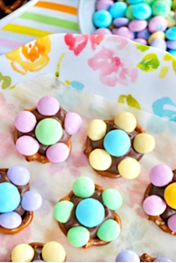 M&M Pretzel flowers on plate with bowls of pretzels and M&Ms to the side.