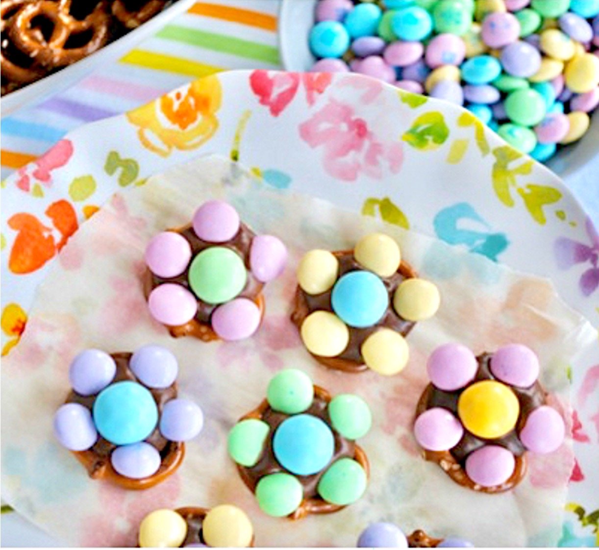 M&M Pretzel flowers on plate with bowls of pretzels and M&Ms to the side.
