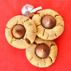 Three peanut butter kiss cookies on napkin.