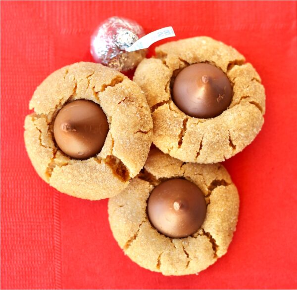 Three peanut butter kiss cookies on napkin.