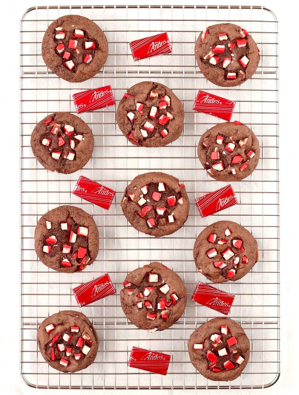 Chocolate peppermint cookies on cookie rack, surrounded by Andes peppermint crunch mints.