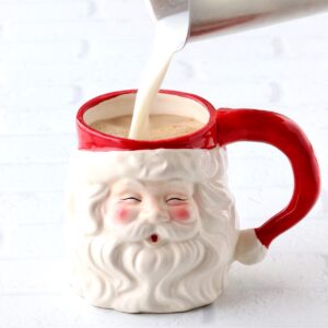 Milk being poured into a Santa mug to make a peppermint mocha.