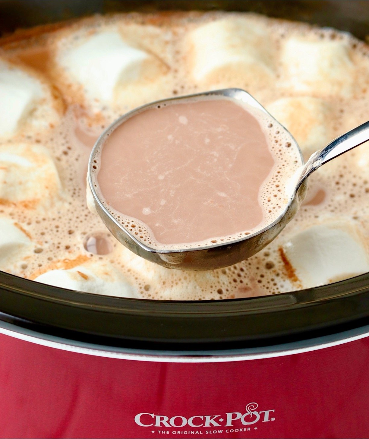 Ladle spooning out hot chocolate from crockpot.