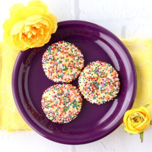 Three sprinkle cookies on plate.