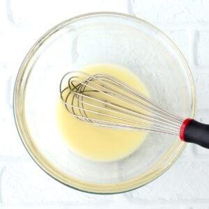 Whisk with pineapple juice in bowl, making sweet and sour sauce.