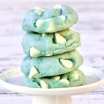 Stack of four winter cookies tinted light blue with white chocolate chips.