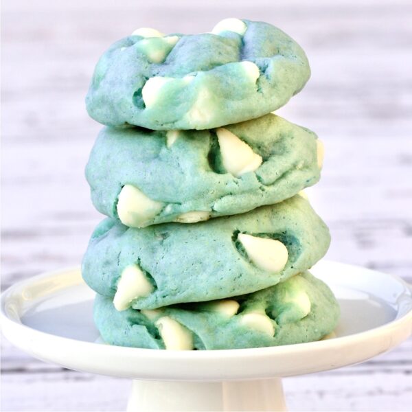 Stack of four winter cookies tinted light blue with white chocolate chips.