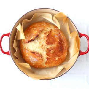 Loaf of crusty artisan bread in dutch oven.